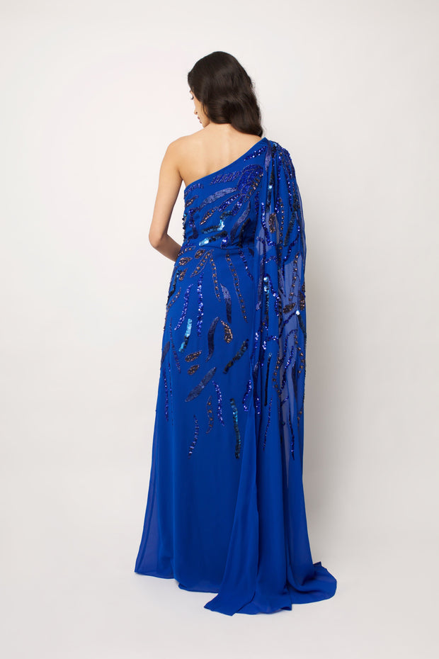 “embroidered cobalt blue one shoulder maxi dress with a draped georgette train”.